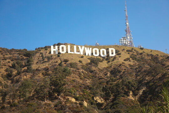 California, USA - September 01, 2019: A wide view of the iconic Hollywood Sign on Mount Lee with the broadcast communication towers standing against a clear blue sky in Los Angeles.