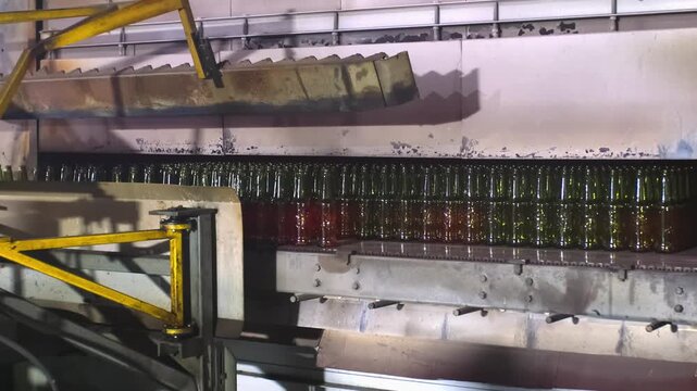 Glass factory, production of glass containers. Molten glass is blown into molds. Robotics in industry. Modern technologies, robotic machines produce products. Technological work at the plant.
