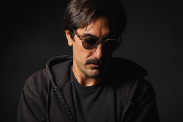 Obraz premium Mysterious man in shades deeply lost in thought, creating an enigmatic vibe