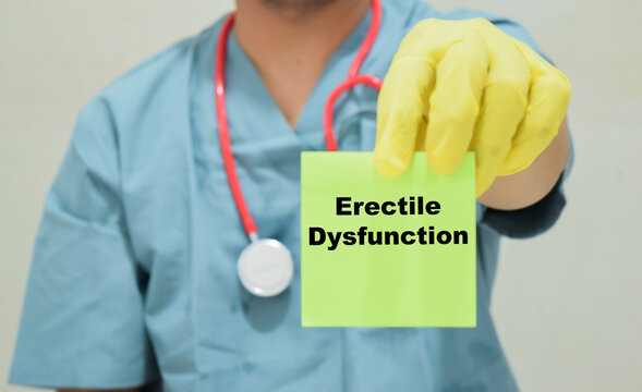 Doctor holds in hands a card with the name of the erectile dysfunction. Medical concept
