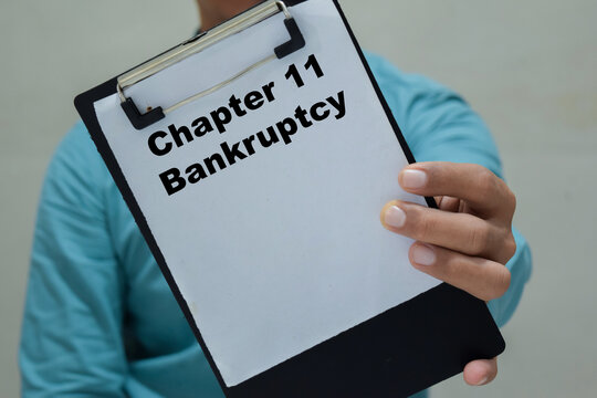 Businessman holds in hands a clipboard with the name of the chapter 11 bankruptcy.