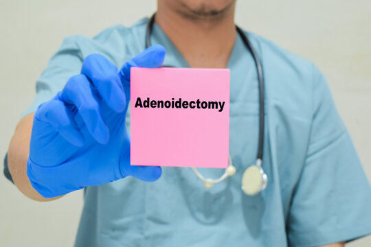 Doctor holds in hands a card with the name of the adenoidectomy. Medical concept