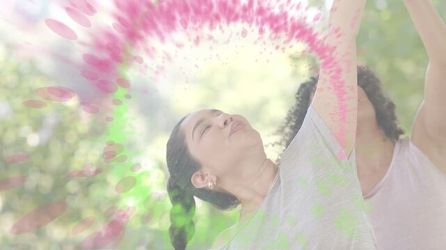 Lead woman raising right arm coach guiding fitness pose reach sparking pink and green ring around fa