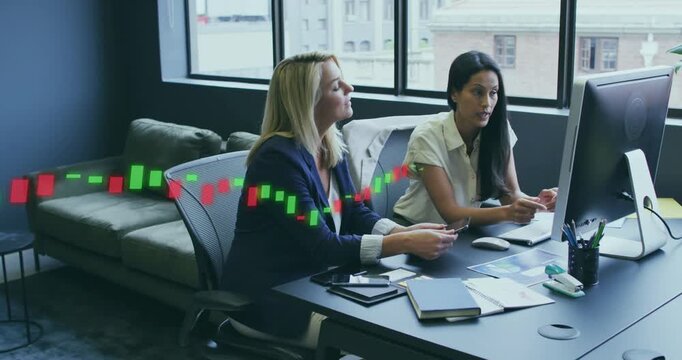 Two colleagues at desk, reacting to live candlestick sweeping across monitor to analyze market
