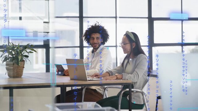 Man glancing from tablet causing blue overlay while woman turning from laptop working in office