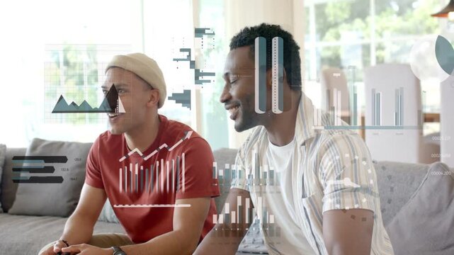 Two male players on sofa pressing pads, initiating HUD charts overlaying them, showing gaming stats