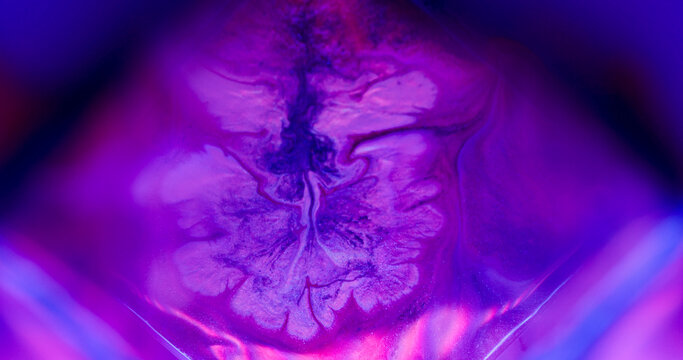 Splatter cube. Neon ink flowing. Defocused purple pink blue color splash chemical texture spilling on abstract acrylic background.
