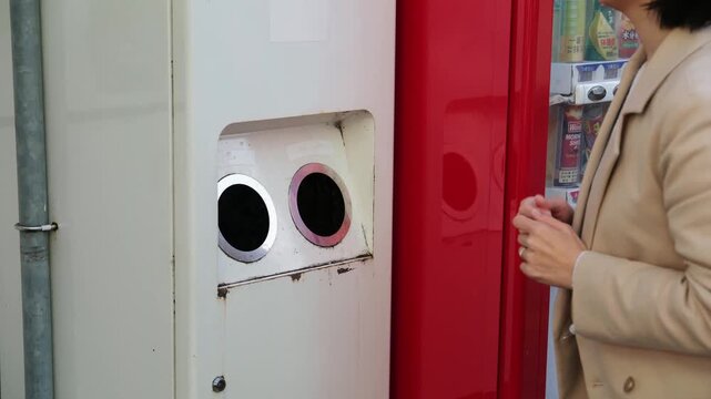 Asian woman putting an empty plastic bottle in a special recycling bin next to a vending machine