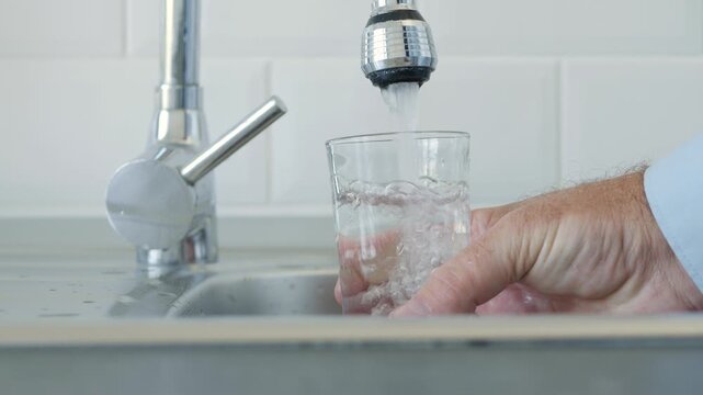 Thirsted Man Filling Up a Glass with Fresh Water from the Kitchen Water Tap.