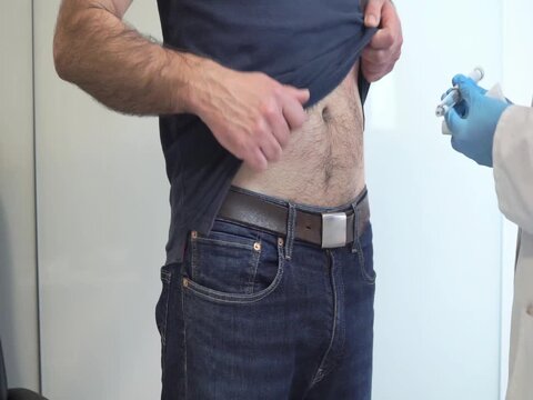 A healthcare provider administers a subcutaneous injection into a patient's abdomen, commonly used for semaglutide treatments.