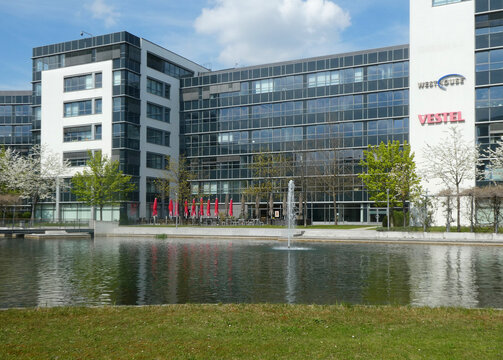 Garching, Germany -   spring view of the business park with the pond, the ornamental water jet and white flowering apple trees