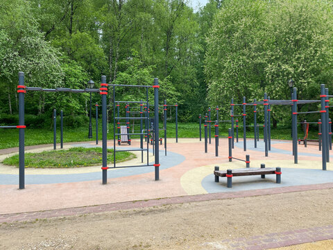 Outdoor calisthenics workout area with pull-up bars in public park. Street workout station featuring metal horizontal bars. Modern fitness equipment located in green park
