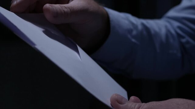 Blurred Shooting with a Person Opening an Envelope and Reading a Letter. Businessman Receiving a Document by Postage.