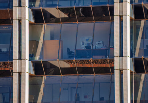 Modern Glass Facade of Office Building with Interior View office interiors with desks and equipment
