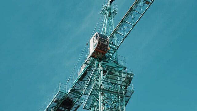 Tower crane cabin and jib structure against clear blue sky