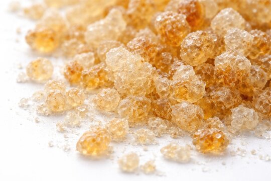 Detailed texture display of natural tragacanth gum granules on bright white background