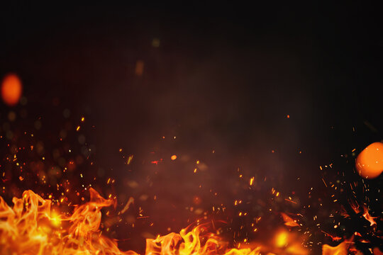 Fire embers particles over black background.  Grill Background - Empty Fired Barbecue On Black . Abstract dark glitter fire particles lights.