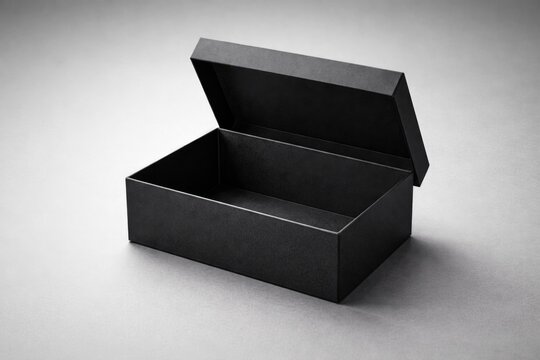 Open black rectangular gift box with folding lid on neutral gray background in forward perspective