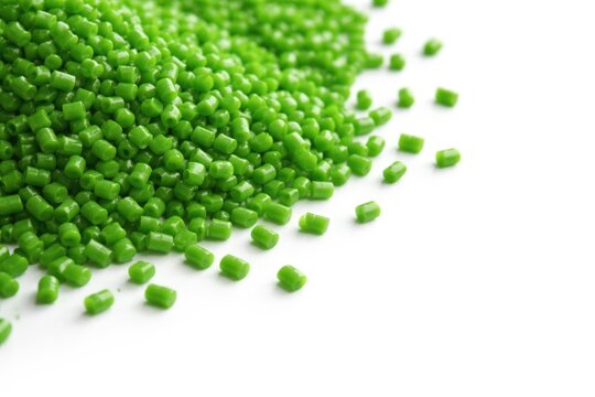 Green polypropylene and polyamide granules on white backdrop with space for text