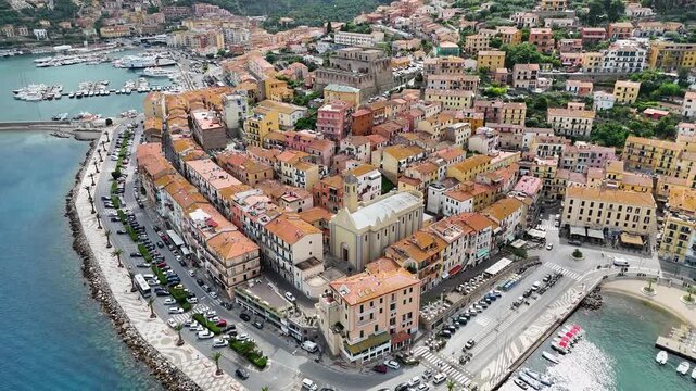 Drone flyover towards the Spanish Fortress and historic church in Porto Santo Stefano