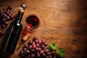 Fototapeta premium Bottle of wine with glass cork and grapes arranged on table showcasing copy space from above