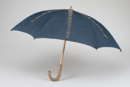 Blue umbrella with decorative darning on a light background.