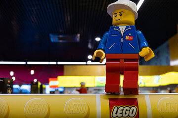 Naklejka premium LEGO worker minifigure on yellow display shelf in store