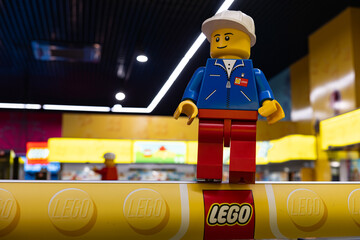 Naklejka premium LEGO worker minifigure on yellow display shelf in store