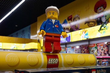 Naklejka premium LEGO worker minifigure on yellow display shelf in store