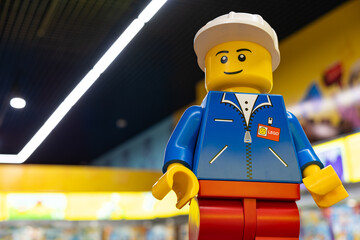Naklejka premium LEGO worker minifigure on yellow display shelf in store