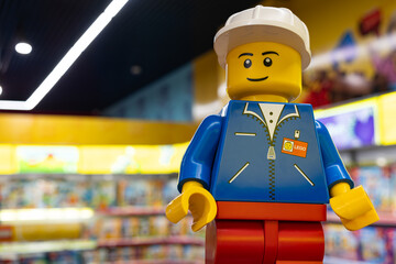 Naklejka premium LEGO worker minifigure on yellow display shelf in store