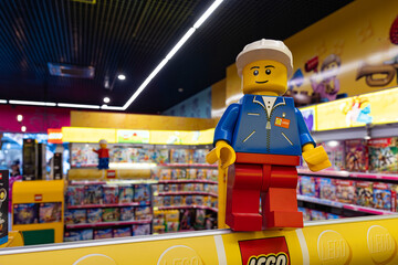 Naklejka premium LEGO worker minifigure on yellow display shelf in store