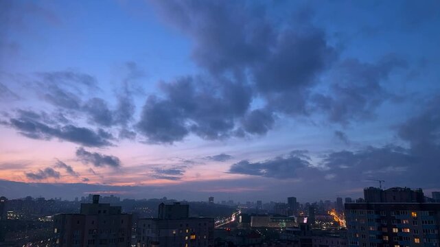 Timelapse of moving clouds over the city from day to night