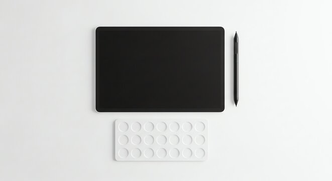 Minimalist workspace with black tablet and white keyboard on white surface.