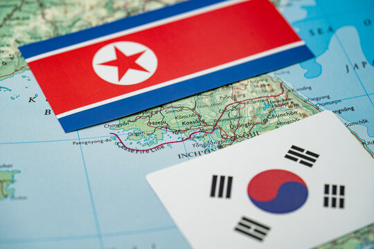 Close up of North Korea and South Korea flags on map of Korean border region.