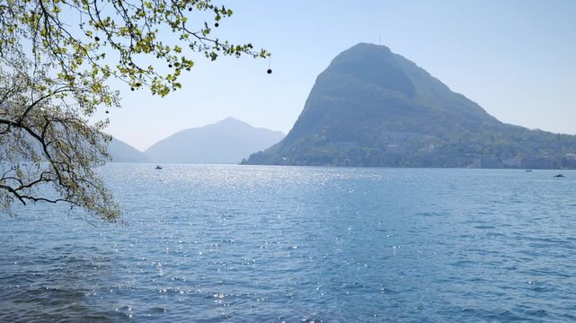 Static shot of Monte San Salvatore and Lake Lugano with shimmering blue water, Switzerland