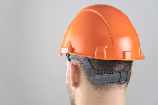 Close-up of a man in an orange construction helmet.