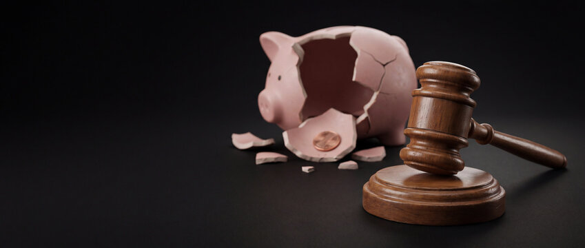 Judge gavel and shattered empty piggy bank with single coin. Bankruptcy law concept