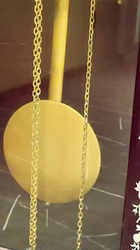 Golden clock pendulum swinging back anf orth, Mechanical Retro Vitage Time Keeping, Analog Chronometer, Ticking Dial