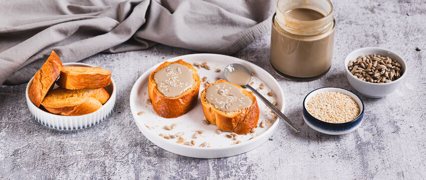 Urbech made from sesame and sunflower seeds on bread on a plate web banner