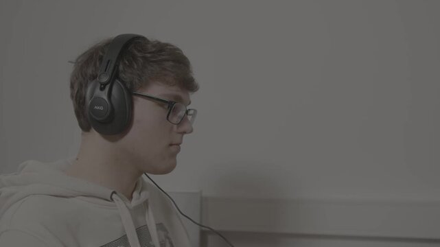 Working at computer with headphones,  Filmed in Log profile with Blackmagic Pocket 6K Pro.