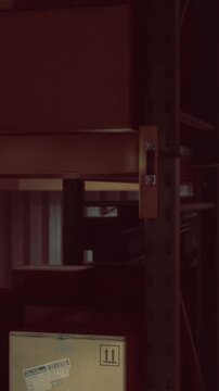 Sturdy metal shelves stand tall, displaying neatly stacked boxes destined for delivery. A sense of anticipation fills the air in this bustling storage space.