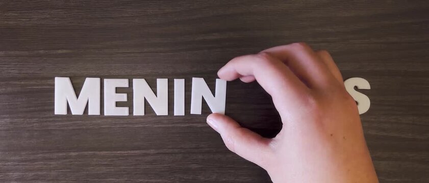 the word meningitis written on a dark background with white block letters or capital letters (fast version)
