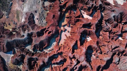 Naklejka premium Aerial view of red, eroded earth with winding ravines