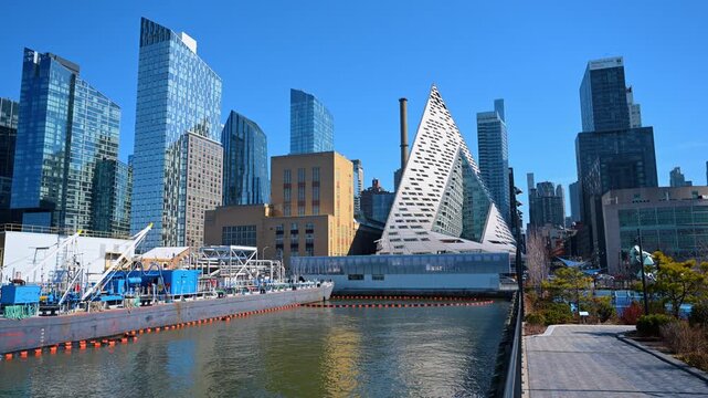 Modern pyramid building architecture in New York City skyline. Daytime view of VIA 57 West residential building and Hudson River waterfront.