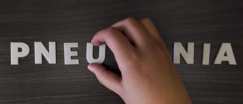 the word pneumonia written on a dark background with white block letters or capital letters (fast version) 
