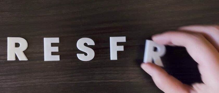persona escribiendo la palabra resfrio en un fondo oscuro con letras blancas y pre hechas (versi&oacute;n r&aacute;pida)
