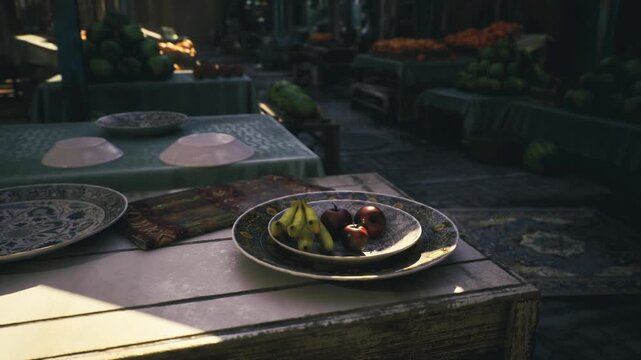 Closeup bowl of fruit on table, cool morning light and empty aisle, ceramic plate with bananas and pomegranate, woven cloth and vendor prepping display
