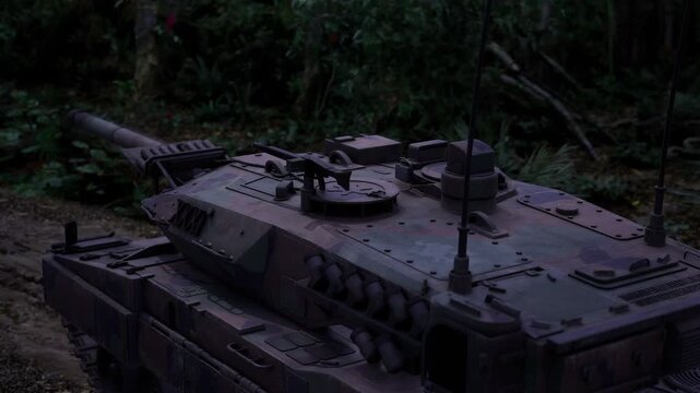 Tank approaching through twilight undergrowth path, lowprofile silhouette blending with foliage, damp leaves and soft soil under tracks, tactical lights