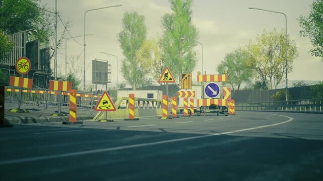 Evening lane closure for resurfacing with reflective signs and barricades marking work perimeter warm light and calm traffic flow suggest planned operation.